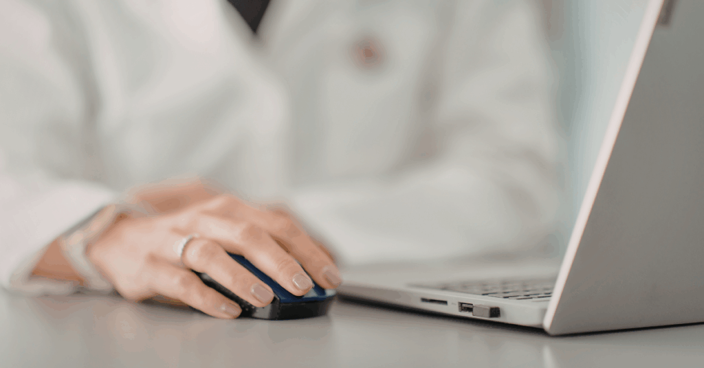 A doctor in a white coat works on a laptop. HIPAA-sensitive marketing is key to avoiding major fines and headaches for your healthcare organization.