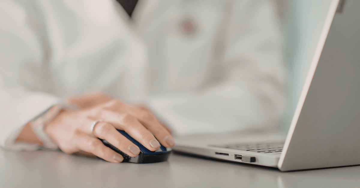 A doctor in a white coat works on a laptop. HIPAA-sensitive marketing is key to avoiding major fines and headaches for your healthcare organization.
