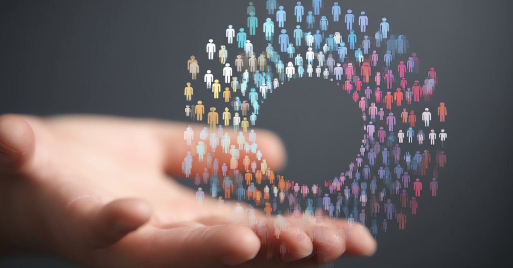 A photo illustration of a palm outstretched, conjuring a circle made out of icons shaped like people, representing the audiences you can reach with proper digital marketing data. hand reaches out, with an illustration of a circle of figures, representing people reached through proepr digital marketing data.