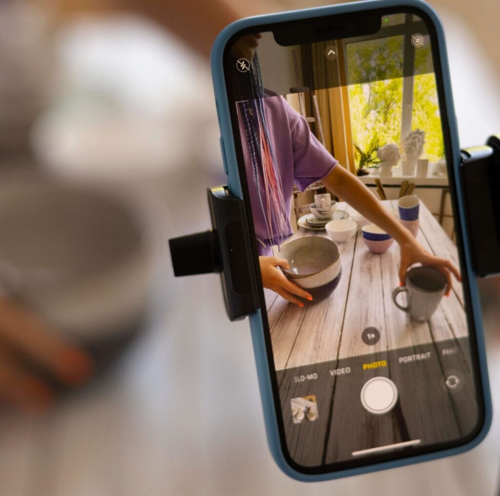A person taking photos of her table set up, representing how video advertising works and how traditional video ads are changing.