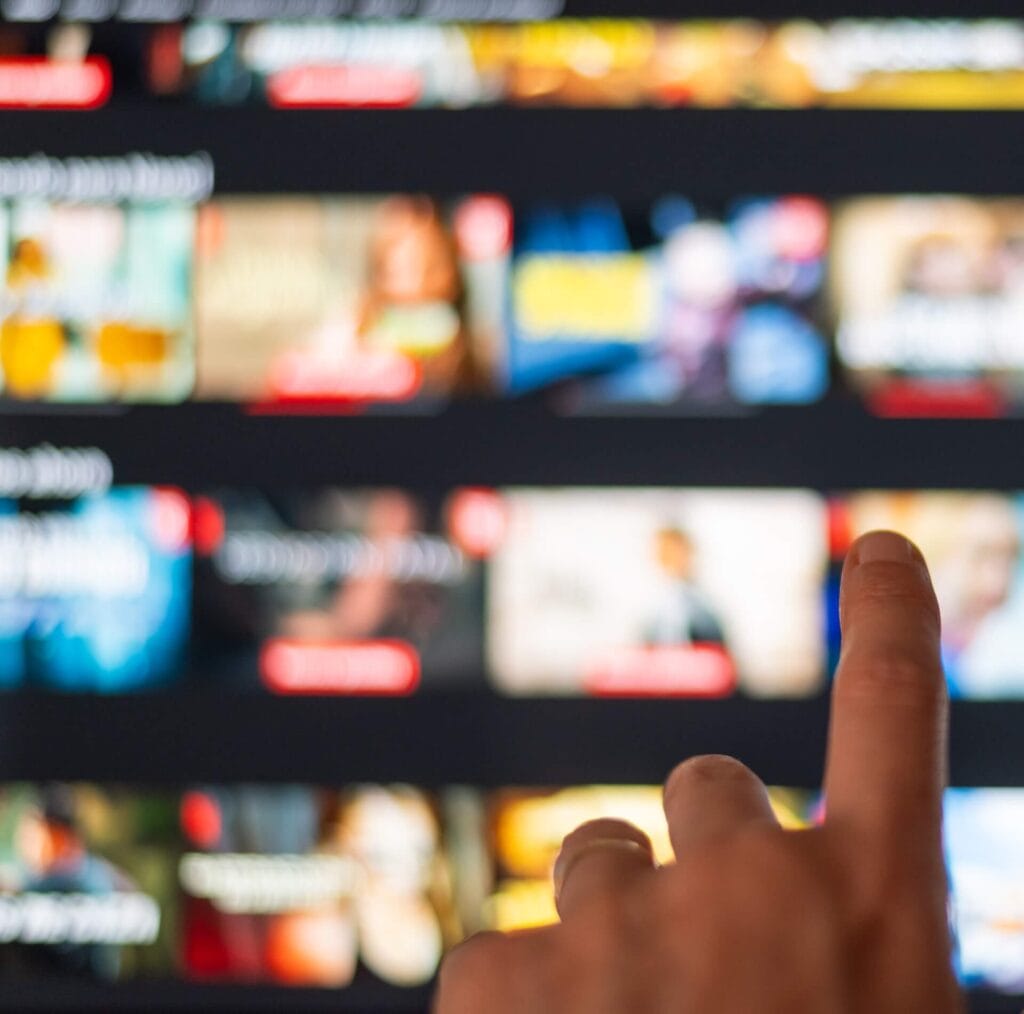A man selecting a movie on a streaming service, demonstrating how advertising on ctv and streaming services is a popular video ad strategy now.