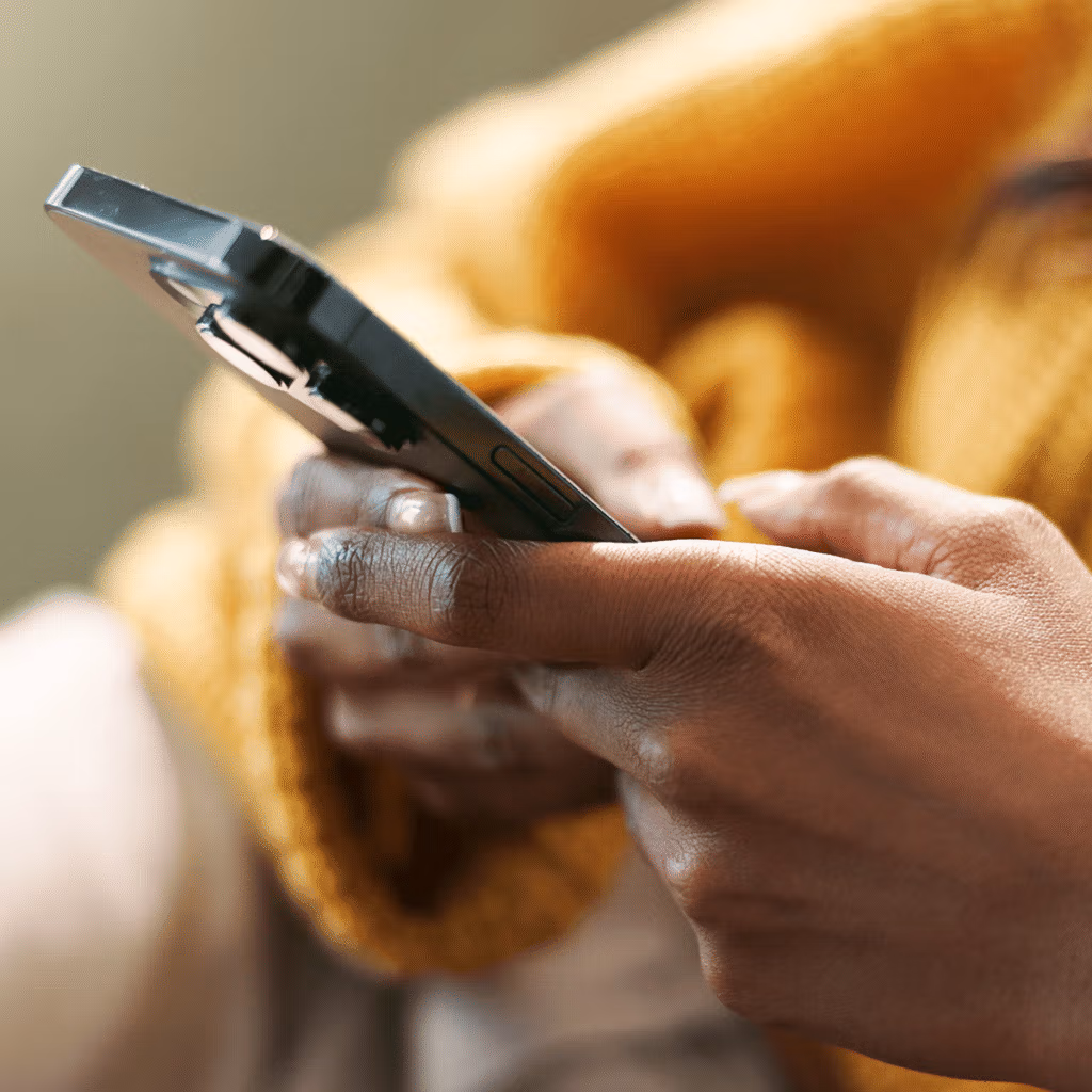 A woman on her phone looking through marketing attribution solutions.